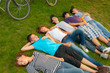 Teenage friends lying on the grass after riding bicycles
