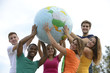 Group of young people holding a globe earth