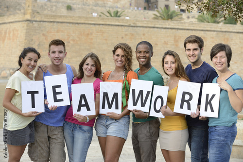 Photo: Group of young people holding teamwork sign Group of young people holding teamwork sign