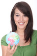 Brunette holding miniature globe