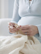 "USA, California, San Francisco, pregnant woman knitting, close-up"