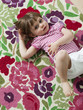 "USA, California, San Francisco, girl (2-3) lying on back on carpet with floral patterns"