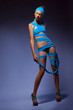 Photo: Trendy fashion woman in blue creative clothes and cap posing Trendy fashion woman in blue creative clothes and cap posing