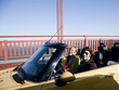 Photo: "USA, California, San Francisco, young couple passing Golden Gate Bridge in convertible car" "USA, California, San Francisco, young couple passing Golden Gate Bridge in convertible car"