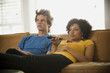 "USA, Utah, Provo, couple sitting on sofa watching TV"