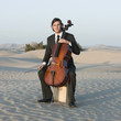 "USA, Utah, Little Sahara, portrait of young man with cello in desert"