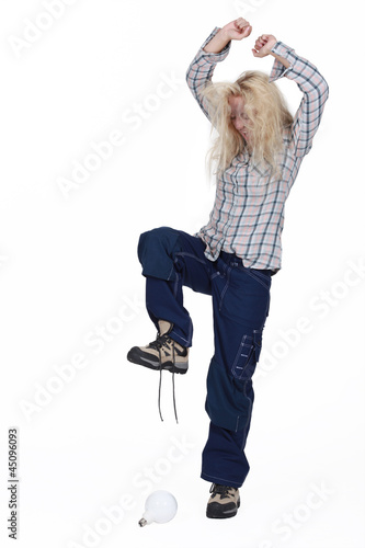 Photo: Furious woman about to crash a light bulb Furious woman about to crash a light bulb