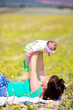 Mother raising her little daughter up high
