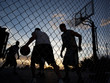 Photo: "USA, Utah, Salt Lake City, four young men playing street basketball, low angle view" "USA, Utah, Salt Lake City, four young men playing street basketball, low angle view"