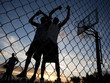 Photo: "USA, Utah, Salt Lake City, three young men playing street basketball, low angle view" "USA, Utah, Salt Lake City, three young men playing street basketball, low angle view"
