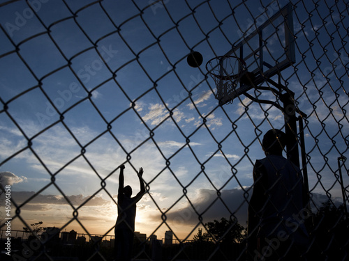 Photo: "USA, Utah, Salt Lake City, two young men playing street basketball" "USA, Utah, Salt Lake City, two young men playing street basketball"