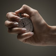 Young woman's hand holding stop clock