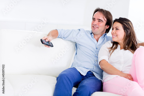 Photo: Couple relaxing at home watching tv Couple relaxing at home watching tv