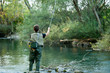 A fisherman fishing on a river