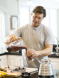 "USA, Utah, Alpine, mature man pouring smoothie in kitchen"