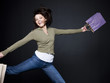 "Young woman with shopping bags jumping, studio shot"