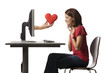 Conceptual picture of young woman receiving red heart out of her computer