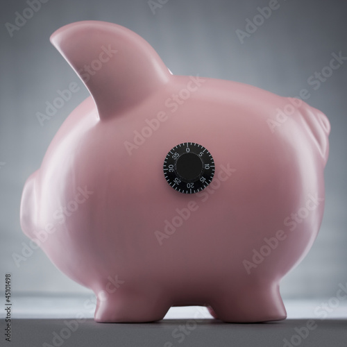 Photo: Studio shot of piggy bank with combination lock Studio shot of piggy bank with combination lock