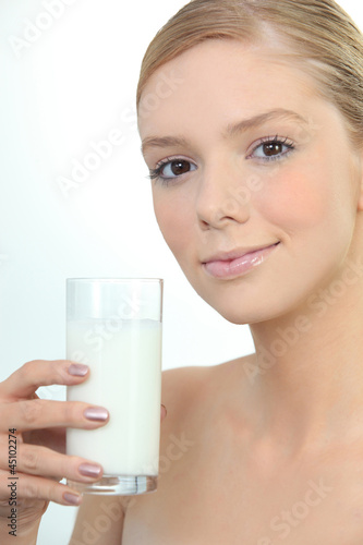 Photo: Woman holding glass of fresh milk Woman holding glass of fresh milk