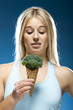 Studio portrait of young woman holding broccoli ice cream