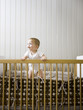 "USA, Utah, Provo, Baby boy (18-23 months) standing in crib"