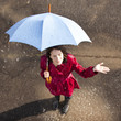 Young woman standing in rain holding umbrella