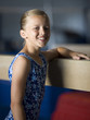 USA, Utah, Orem, portrait of girl (10-11) leaning on balance beam in gym
