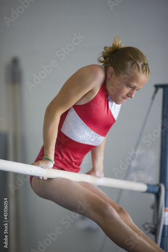 Photo: USA, Utah, Orem, girl (10-11) exercising on pole in gym USA, Utah, Orem, girl (10-11) exercising on pole in gym