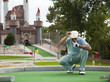 "USA, Utah, Orem, Man lining up shot on miniature golf course"