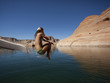 "USA, Utah, Young woman jumping into Lake Powell"
