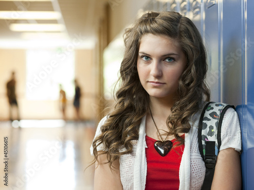 Photo: "USA, Utah, Portrait of teenage girl (14-15) in school corridor" "USA, Utah, Portrait of teenage girl (14-15) in school corridor"
