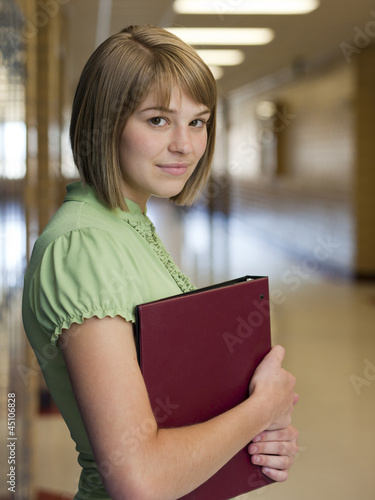 Photo: "USA, Utah, Spanish Fork, Portrait of school girl (16-17) holding file in corridor" "USA, Utah, Spanish Fork, Portrait of school girl (16-17) holding file in corridor"