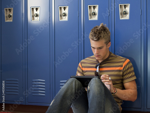 Photo: "USA, Utah, Spanish Fork, School boy (16-17) using digital tablet by lockers" "USA, Utah, Spanish Fork, School boy (16-17) using digital tablet by lockers"