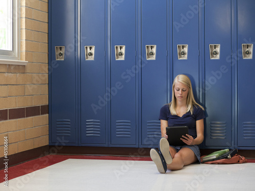 Photo: "USA, Utah, Spanish Fork, School girl (16-17) using digital tablet by lockers" "USA, Utah, Spanish Fork, School girl (16-17) using digital tablet by lockers"
