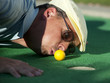 "USA, Utah, Orem, Man blowing air to push golf ball"