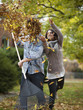 "USA, Utah, Provo, Young woman throwing leaves over husband in garden"