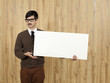Businessman holding blank placard in office