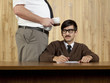 Boss by smug businessman at desk in office