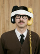 Businessman with telephones strapped to head in office