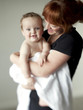 "USA, Utah, Orem, Mother holding baby (6-11 months) wrapped in towel"