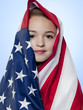 Studio portrait of girl (10-11) wrapped in american flag