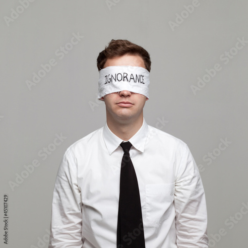 Photo: Studio portrait of young man with blindfold Studio portrait of young man with blindfold
