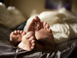 "USA, Utah, Provo, Close-up of feet of couple lying in bed"