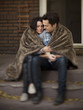 Photo: "USA, Utah, Provo, Young couple wrapped in blanket sitting on steps in front of house" "USA, Utah, Provo, Young couple wrapped in blanket sitting on steps in front of house"