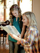 Photo: "USA, Utah, Cedar Hills, Girl (8-9) showing examination results with grade A to mother" "USA, Utah, Cedar Hills, Girl (8-9) showing examination results with grade A to mother"