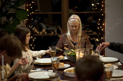 Photo: "USA, Utah, Cedar Hills, Three generation family with girl (8-9) holding hands at Christmas table" "USA, Utah, Cedar Hills, Three generation family with girl (8-9) holding hands at Christmas table"