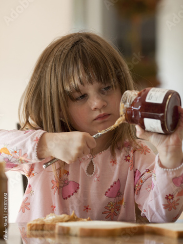 Photo: "USA, Utah, Cedar Hills, Girl (4-5) putting jam on bread" "USA, Utah, Cedar Hills, Girl (4-5) putting jam on bread"