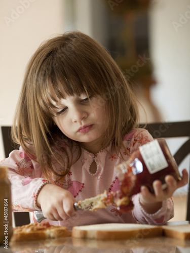 Photo: "USA, Utah, Cedar Hills, Girl (4-5) putting jam on bread" "USA, Utah, Cedar Hills, Girl (4-5) putting jam on bread"