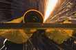 man in blue coveralls with a power grinder