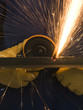 man in blue coveralls with a power grinder